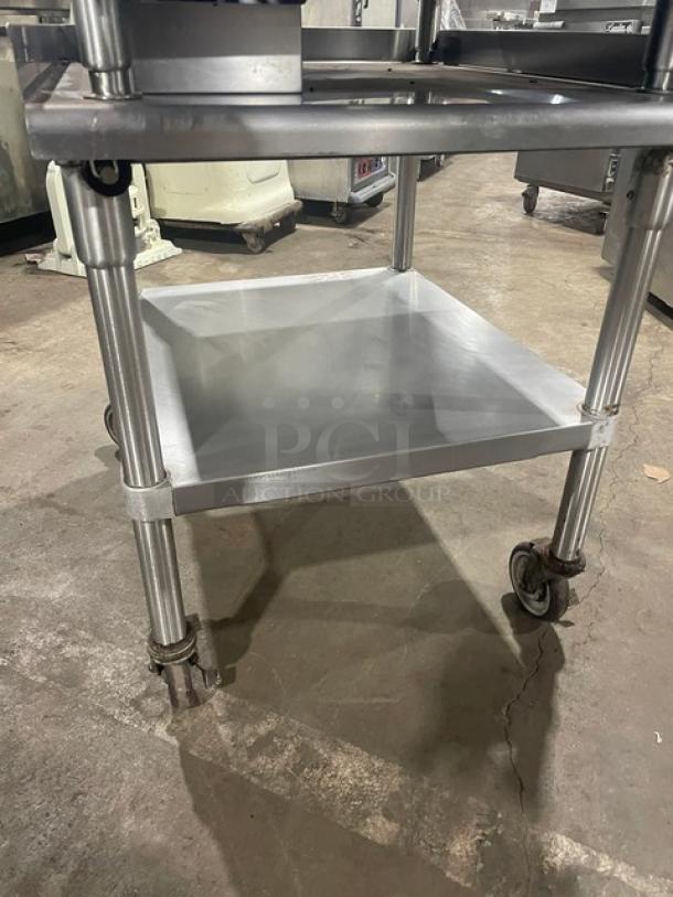 Garland stainless steel natural gas flat griddle with thermostatic control, back and side splash, on legs, with undershelf cart on casters.