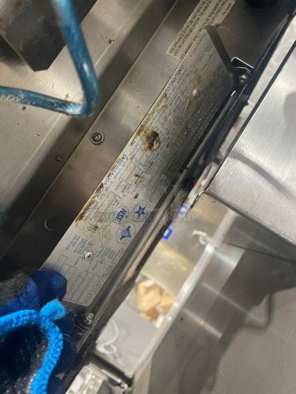 Garland stainless steel gas-powered countertop flat griddle with thermostatic control. Features back and side splash, on legged cart with undershelf. Visible wear on label.