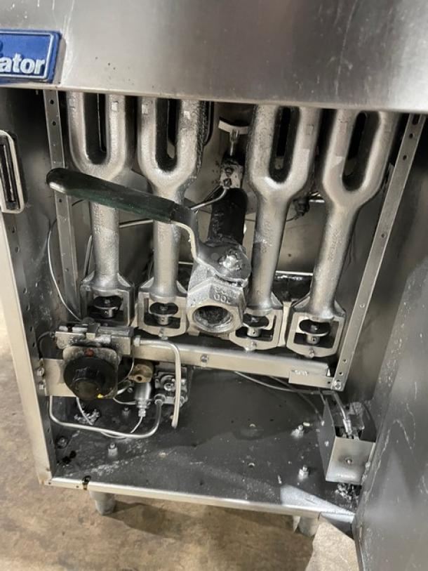Pitco Frialator commercial stainless steel gas fryer. Features basket hanger, backsplash, and fry basket. On legs.