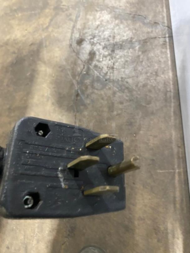 Close-up of a three-prong electrical plug for the Eagle Group 3-Well Hot Food/Steam Table.