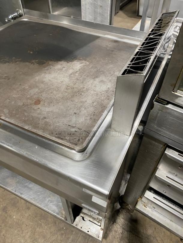 Electrolux Thermaline Series stainless steel flat top grill, natural gas-powered, enclosed open base, on legs, used condition.