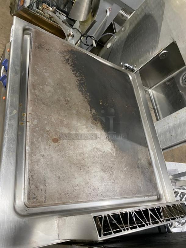Electrolux Thermaline Series stainless steel flat top grill, natural gas powered, with open base, on legs; shows wear.