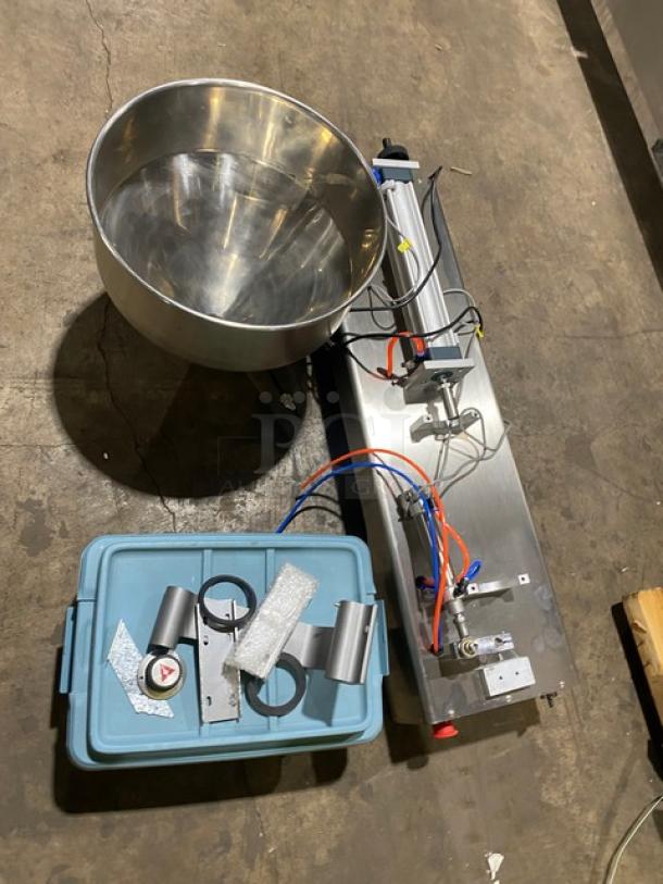 Vevor countertop liquid filling machine with stainless steel hopper, pneumatic controls, and mixed attachments, shown on a warehouse floor.