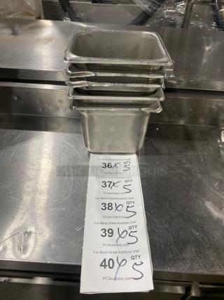 Stacked commercial stainless steel hotel pans, clean condition, with auction sheet showing bid quantities and URLs.