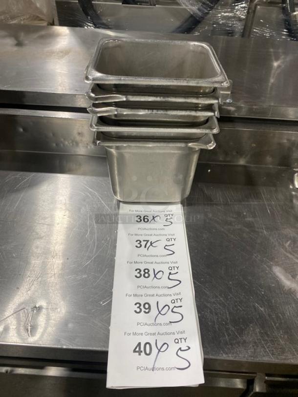 Stack of commercial stainless steel hotel pans, durable, suitable for steam tables, with auction labels detailing quantities.