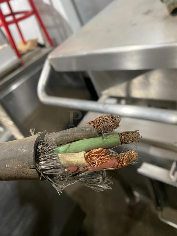 Frayed electrical cable with exposed copper wires, indicating potential damage or wear.