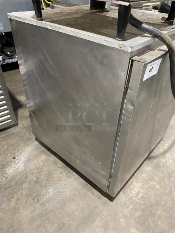 Commercial stainless steel undercounter refrigerator with solid single door, poly-coated rack, and casters; good condition.