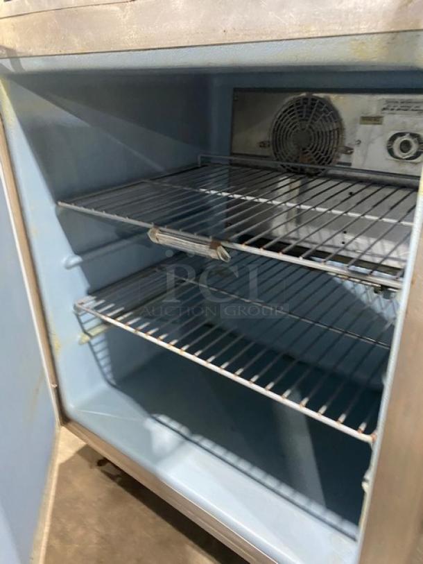 Commercial stainless steel single door undercounter refrigerator with poly-coated wired rack, on casters, good condition.