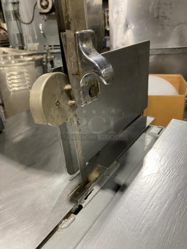 Biro Model 22 stainless steel vertical band meat saw with electric power, portion control slide-top table, and on legs.