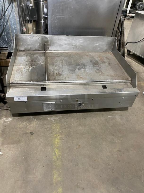 Woodstone 48" stainless steel countertop split-top plancha griddle with natural gas power, back and side splash, on legs.