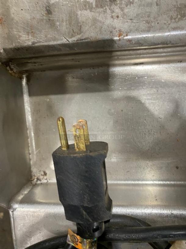 Woodstone 48" stainless steel natural gas countertop griddle plug detail, showing a standard 3-prong plug. Griddle in used condition.