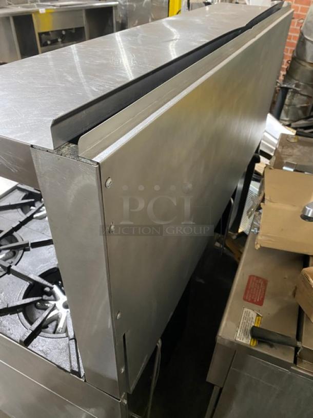 Garland H284 stainless steel 10 burner range with double oven, backsplash, salamander shelf, and wired oven rack. In good condition.