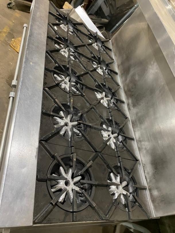 Garland H284 stainless steel 10-burner range with double oven, backsplash, and salamander shelf. Natural gas, on legs.