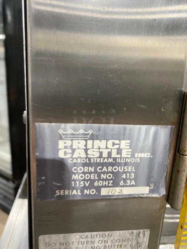 Prince Castle Model 413 stainless steel corn carousel with equipment stand. Features 115V power, serial number 102. On casters.