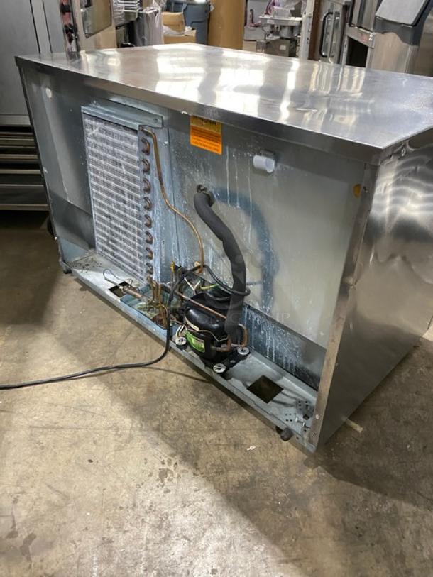 Delfield stainless steel 2-door refrigerated worktop table, model UC4048-STAR, with Energy Star certification. Features poly-coated wired rack and casters. Serial number 1407152002044.