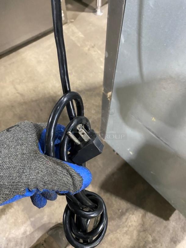 Turbo Air M3 Series refrigerator power cord shown with a gloved hand, highlighting the plug and condition.