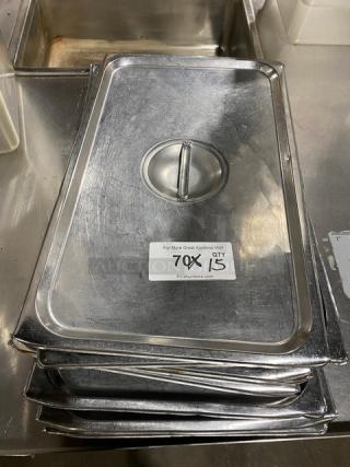 Commercial stainless steel steamtable pan lid with handle, stack of 15. Used condition, visible surface wear.