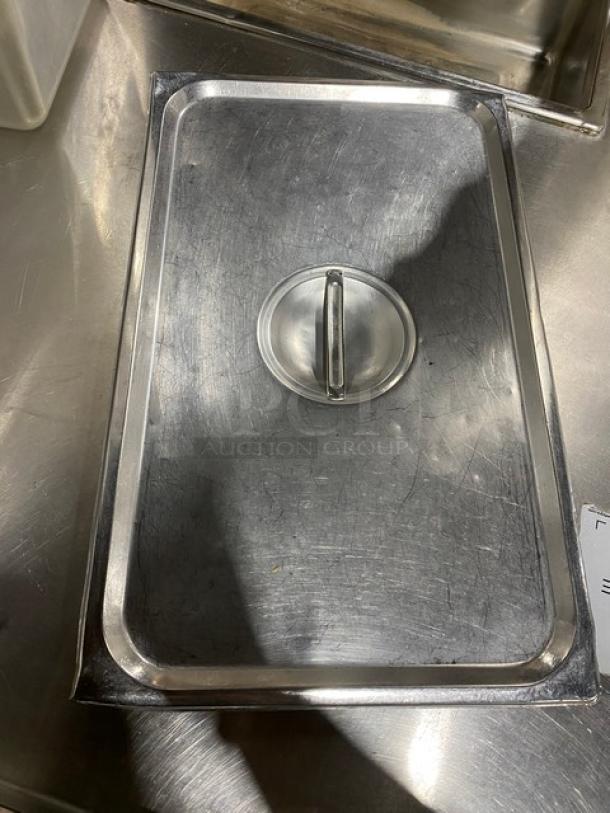 Commercial stainless steel steamtable pan lid with handle, rectangular, lightly scratched surface, 15" size.