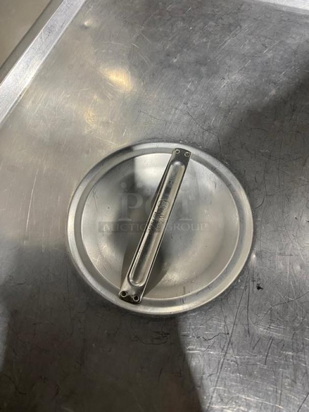 Commercial stainless steel steamtable pan lid with handle, used condition. Marking shows brand logo.