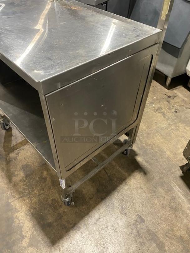 Commercial stainless steel worktop/prep table with enclosed base, double foldable shelf, and casters. Good condition.