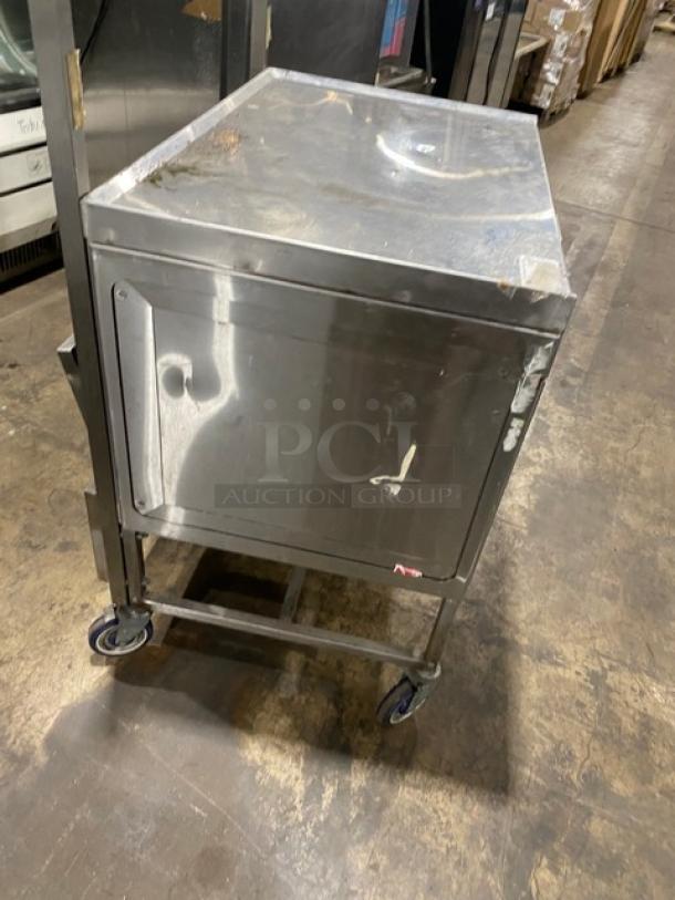 Commercial stainless steel worktop/prep table with enclosed base, double foldable shelf, and casters. Used condition.