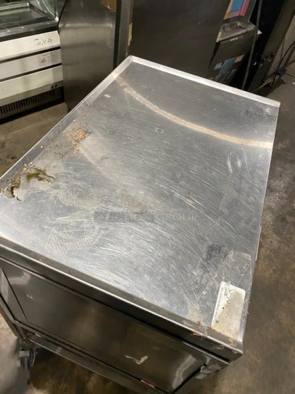 Commercial stainless steel dry enclosed-base worktop/prep table with wear, double foldable shelf, on casters for easy mobility.