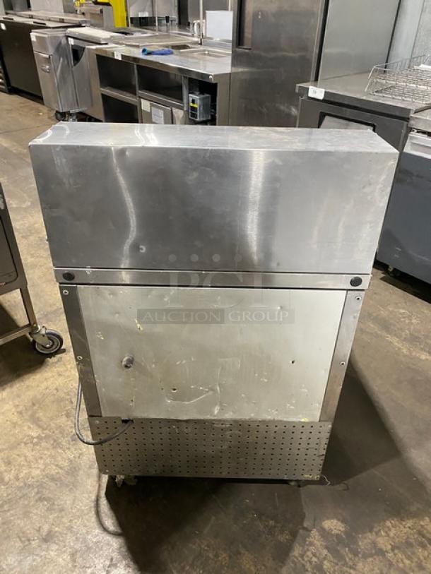 True TSSU-27-12M-B stainless steel refrigerated prep table, single door, on casters, back view in used condition.