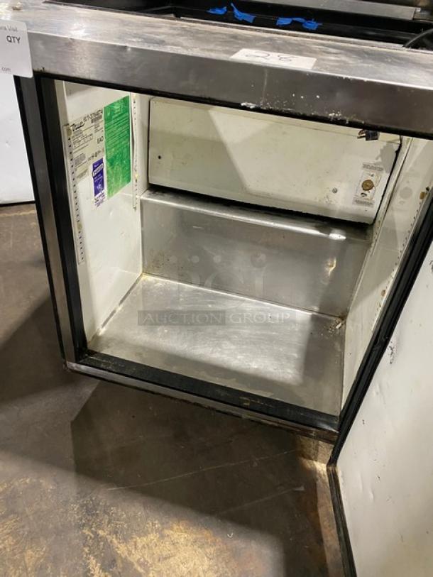 True TSSU-27-12M-B stainless steel refrigerated prep table, single door, on casters, 115V, interior view, some wear visible.