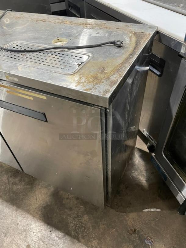 Avantco stainless steel 2-door kegerator, model 178UDD60HCS, featuring double tower/tap cut-outs and drip tray. Visible wear.