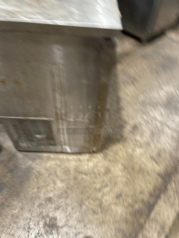 Blurry image of an Avantco 178UDD60HCS stainless steel kegerator with visible surface imperfections.