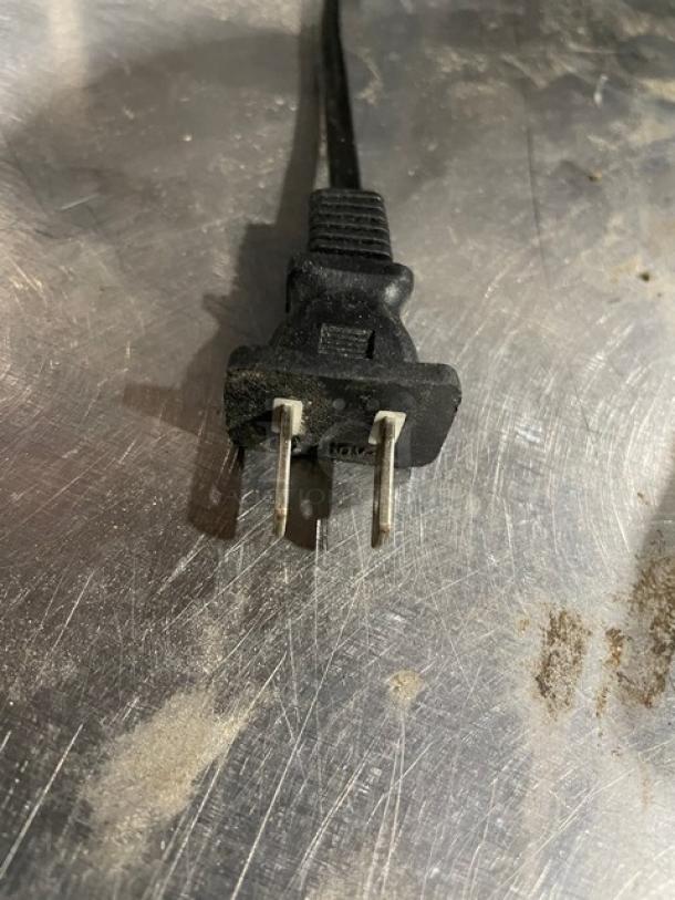 Power plug of Commercial Electric Powered Manual Impulse Sealer Model 300, compatible with 110V/210-250V, shown on metal surface.