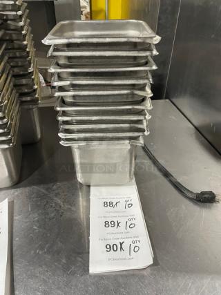 Commercial stainless steel hotel/steamtable pans stacked, showing durable construction. Pan dimensions appear standard, in good condition. Tags list auction details.