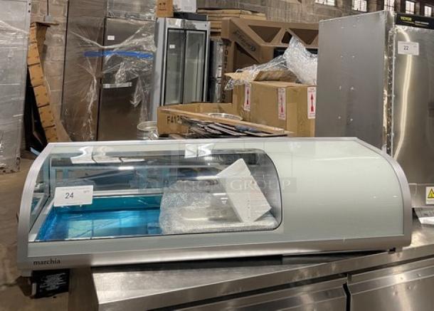 Marchia MSU140S 46" curved glass refrigerated sushi display with LED lights, double glass sliding doors, and new pans.