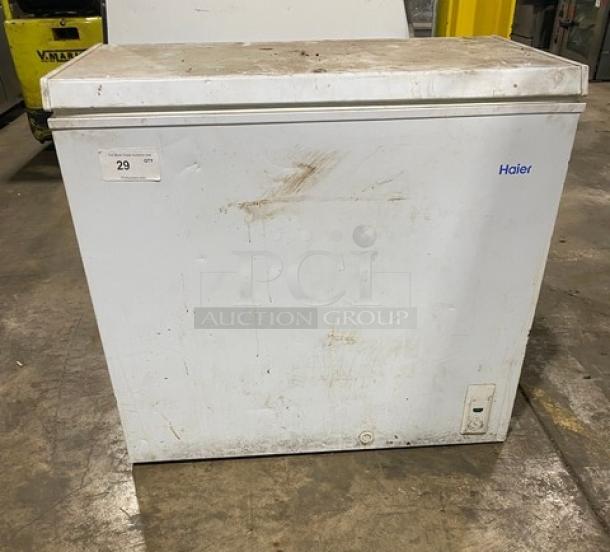 Haier commercial free-standing chest freezer, model HE71CL53NW, with top hinged lid. Visible wear on exterior. 115V, 1 phase.