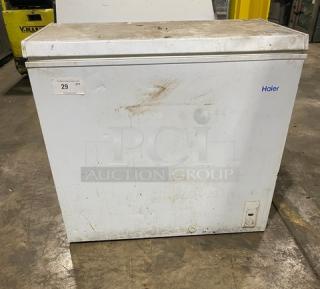 Haier commercial free-standing chest freezer, model HE71CL53NW, with top hinged lid. Visible wear on exterior. 115V, 1 phase.