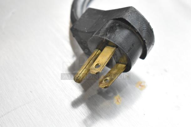 Close-up image of a black power plug with three prongs on a Beverage Air UCR27A cooler.