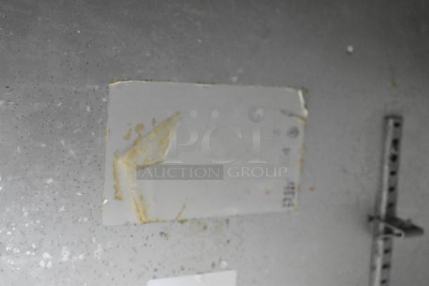 Beverage Air stainless steel 3-door undercounter cooler on casters, 115V, 1 phase; peeling label visible, showing signs of wear.