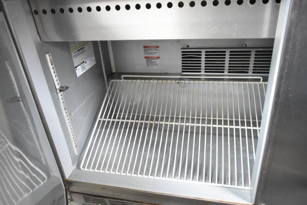 Beverage Air SPE60-24M stainless steel prep table interior with shelving and ventilation grill. Commercial casters visible.