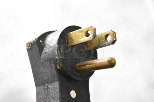 Close-up of a three-prong electrical plug for the Beverage Air SPE48-18M-HMP prep table, showing wear on metal prongs.