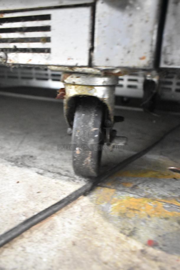 Beverage Air SPE48-18M-HMP commercial sandwich prep table caster showing signs of use and wear.