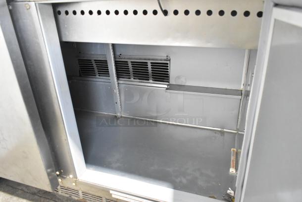 Beverage Air SPE48-18M-HMP stainless steel prep table interior, showing clean, spacious storage on commercial casters.