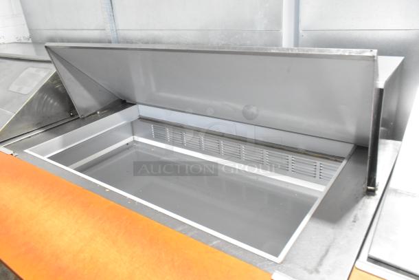 Beverage Air SPE48-18M stainless steel prep table with open lid, commercial casters, excellent condition.
