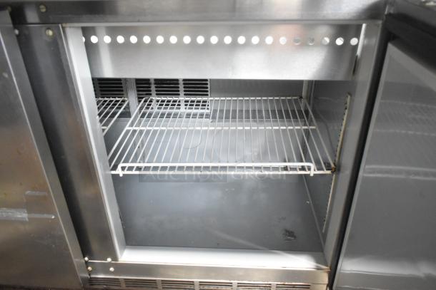 Beverage Air SPE48-18M stainless steel sandwich salad prep table with Bain Marie, seen with open metal shelving.