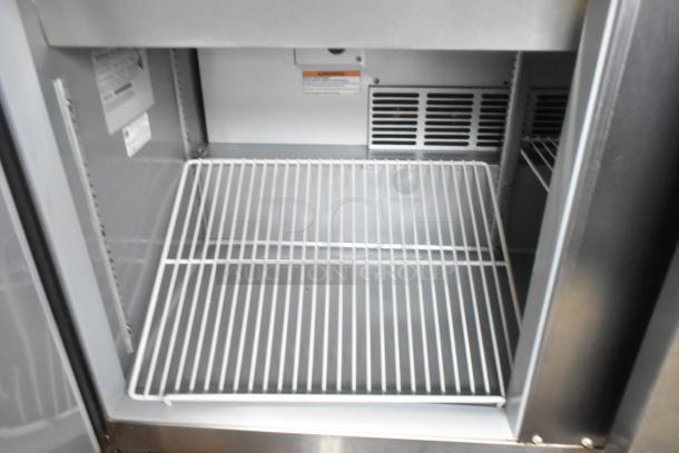 Beverage Air SPE48-18M stainless steel prep table interior, showing wire shelf and labeling, in excellent condition.