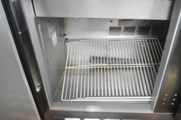 Beverage Air SPE48-18M stainless steel sandwich prep table, interior view showing wire shelf and ventilation, on casters.