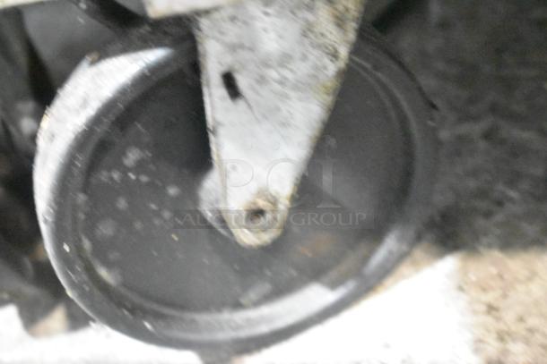 Close-up of a commercial caster on Beverage Air SPE48-18M prep table. Wheel shows signs of wear.