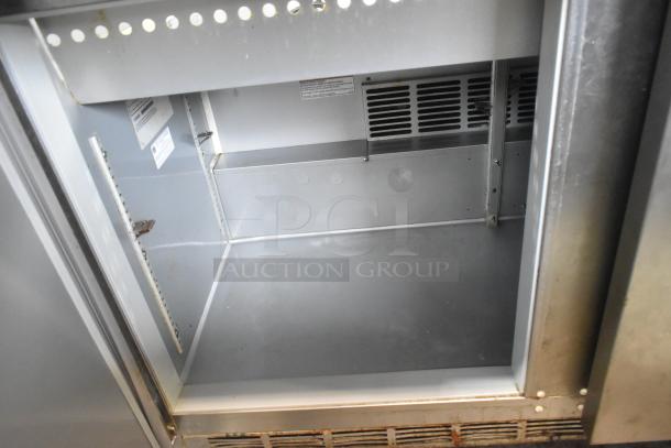Beverage Air SPE48-18M-HMP stainless steel prep table interior, showing storage space and ventilation. Signs of use visible.