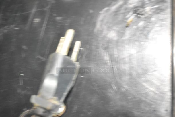 Blurry image of an electrical plug on a dark surface. Not related to Bunn ULTRA-2 Slushie Machine.