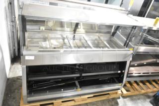 Brand new metal commercial floor-style open grab-and-go merchandiser with visible scratches and dents, on a pallet.