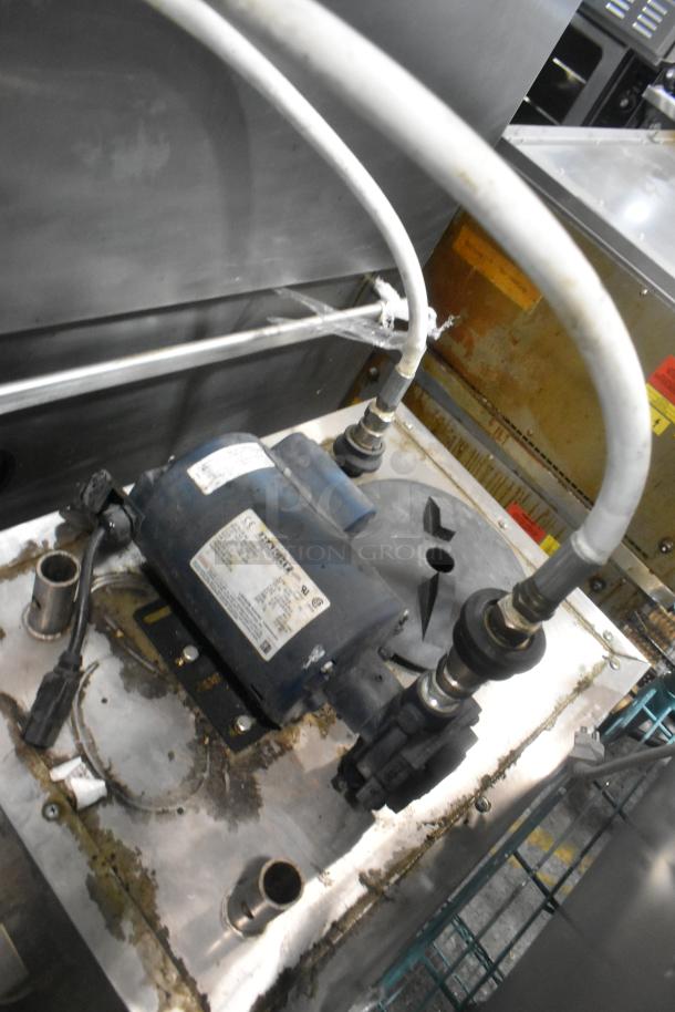 Stainless steel commercial oil filter with visible hoses and electrical wiring, mounted on commercial casters, shows some wear.